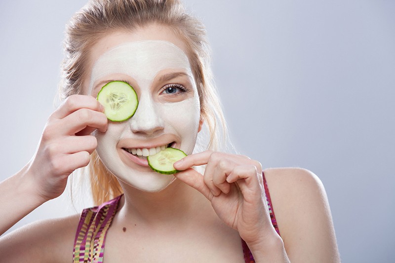 Woman With Slice Of Cucumber